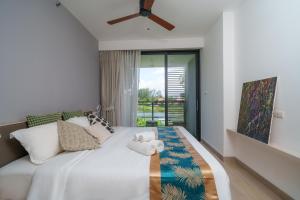 a bedroom with a bed with a ceiling fan at Cassia Apartment 1 in Bang Tao Beach +85 photos