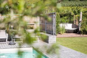 a wooden deck with a bench and a table and chairs at Ferienwohnungen Hochbrunner in Terlano