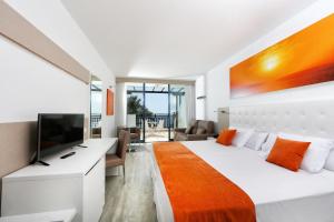 a bedroom with a large bed and a television at Sandos Papagayo in Playa Blanca +37 photos