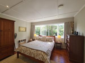 a bedroom with a large bed and a window at Coromandel Eco Sanctuary in Coromandel Town