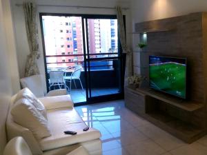 sala de estar con sofá y TV en una habitación en AP Top Condominio Porto de Iracema, en Fortaleza