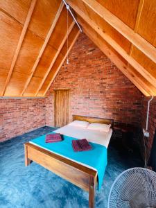 a bed in a room with a brick wall at Leopardbay Cabanas Arugambay in Arugam Bay