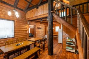 a dining room in a log cabin with wooden walls at COTTAGE SaY in Nasushiobara