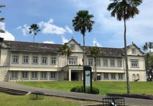 a large building with palm trees in front of it at Point Stay GH in Kuching