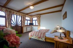 a bedroom with a bed and a table and windows at Willa Pod Miedzą 200 m do Term in Bukowina Tatrzańska