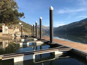 a dock on a lake with mountains in the background at Quinta Da Marka in Covas do Douro