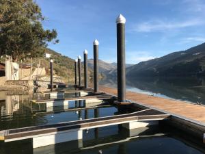 un muelle en un lago con montañas en el fondo en Quinta Da Marka, en Covas do Douro