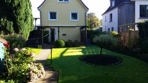 a yard with a house and a small garden at Ferienhaus am Hasselberg Husum in Husum