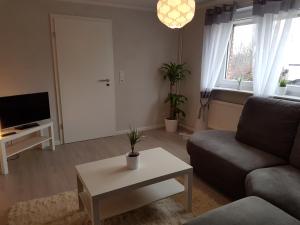 a living room with a couch and a table at Ferienhaus am Hasselberg Husum in Husum