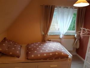 Bett in einem Zimmer mit Fenster in der Unterkunft Ferienhaus am Hasselberg Husum in Husum
