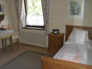 a small bedroom with a bed and a window at Pension Landhaus Ingrid in Loich