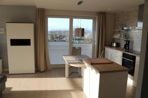 a kitchen with a table and a large window at Ostseezauber in Ostseebad Sellin