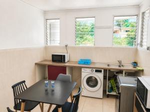 a kitchen with a table and a washing machine at Harmony Caraibes in Le Robert