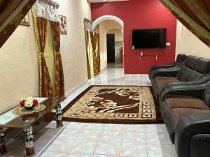 a living room with a couch and a flat screen tv at Kannan homestay in Kamunting