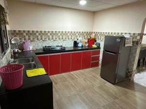 a kitchen with red cabinets and a stainless steel refrigerator at Kannan homestay in Kamunting +7 photos