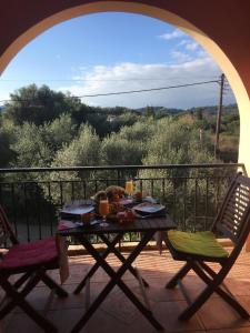 a table and two chairs on a balcony with a view at The Olive Tree House in Kompítsion