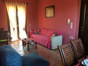 a living room with a red couch with a dog on it at The Olive Tree House in Kompítsion