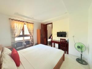 a bedroom with a white bed and a desk and a window at Gioan Boutique Villa in Hoi An