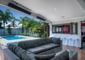 a living room with a couch and a swimming pool at Malibu Palms - Echuca Holiday Homes in Moama