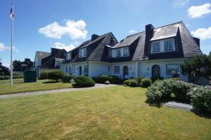 una gran casa blanca con techo de gambrel en Ferienwohnung Sönshörn, en Munkmarsch