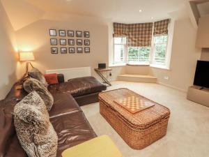 a living room with a leather couch and a television at Kelsick Heights in Ambleside