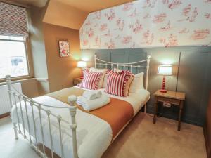 a bedroom with a bed with red and white pillows at Kelsick Heights in Ambleside
