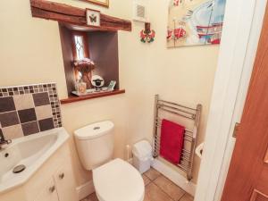 a bathroom with a toilet and a sink at Piggery Cottage in Wigton +17 photos