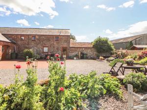 a garden with flowers in front of a building at Piggery Cottage in Wigton