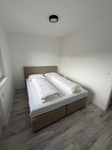 a white bedroom with a bed in a room at Stan centar Gračanica in Gračanica