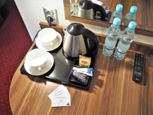 a hotel room table with a tea kettle and water bottles at Villa Masoneria in Łódź