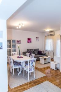 奧西耶克的住宿－Apartment Flores，客厅配有白色的桌子和椅子