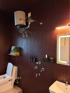 a bathroom with a toilet and a sink and a mirror at Sunshine Stays in Siliguri +9 photos