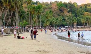 a group of people walking on a beach at Andaman Beach Resort in Shādipur
