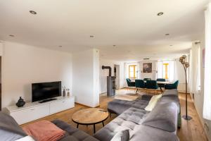 a living room with a couch and a tv at Ferienhaus - Großer Büchelstein in Grattersdorf
