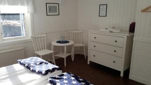a bedroom with a bed and a table and chairs at Missionshuset Bed & Breakfast in Sandhamn
