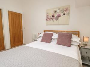 a bedroom with a large white bed with two pillows at Coney Garth Barn in Beckermet