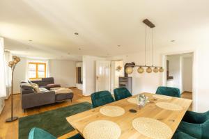 a living room with a wooden table and green chairs at Ferienhaus - Großer Büchelstein in Grattersdorf