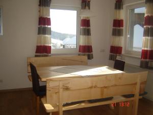 une table et une chaise dans une chambre avec fenêtre dans l'établissement Biohof Stockinger, à Kirchbach