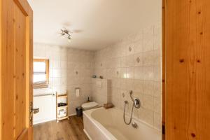 a bathroom with a white tub and a toilet at Ferienhaus - Großer Büchelstein in Grattersdorf +24 photos