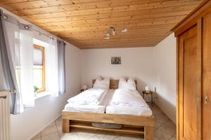 a bed in a room with a wooden ceiling at Ferienhaus - Großer Büchelstein in Grattersdorf
