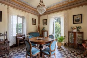 a dining room with a table and chairs and a chandelier at Lake Orta Villa Retreat in Pella +33 photos