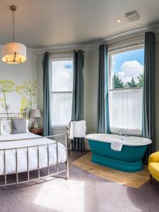 a bedroom with a bed and a tub in a room at The High Field Town House in Birmingham