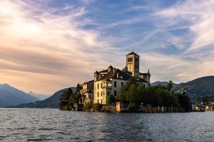a castle on an island in the water at Lake Orta Villa Retreat in Pella