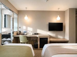 a hotel room with two beds and a flat screen tv at V-one Hotel - Ningxia No. 2 Inn in Taipei