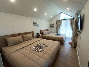 a bedroom with two beds and a television in it at Honeymoon in Pong Talong