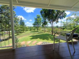 a chair on a porch with a view of a yard at Honeymoon in Pong Talong