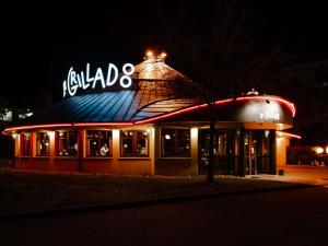 a restaurant with a sign on top of it at night at ibis budget Rodez in Rodez