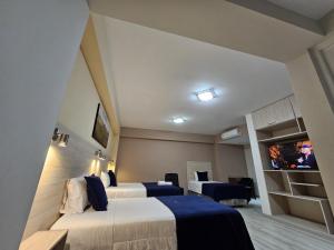 a hotel room with two beds and a flat screen tv at Valle Sur Hotel Moquegua in Moquegua