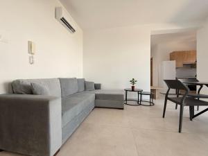 a living room with a gray couch and a table at Esmee In, Engomi in İncirli