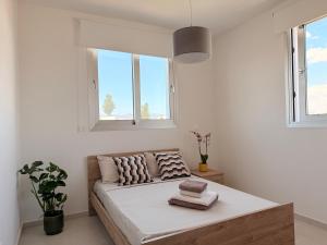 a bedroom with a bed and two windows at Esmee In, Engomi in İncirli